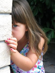 picture of girl peeking from behind wall